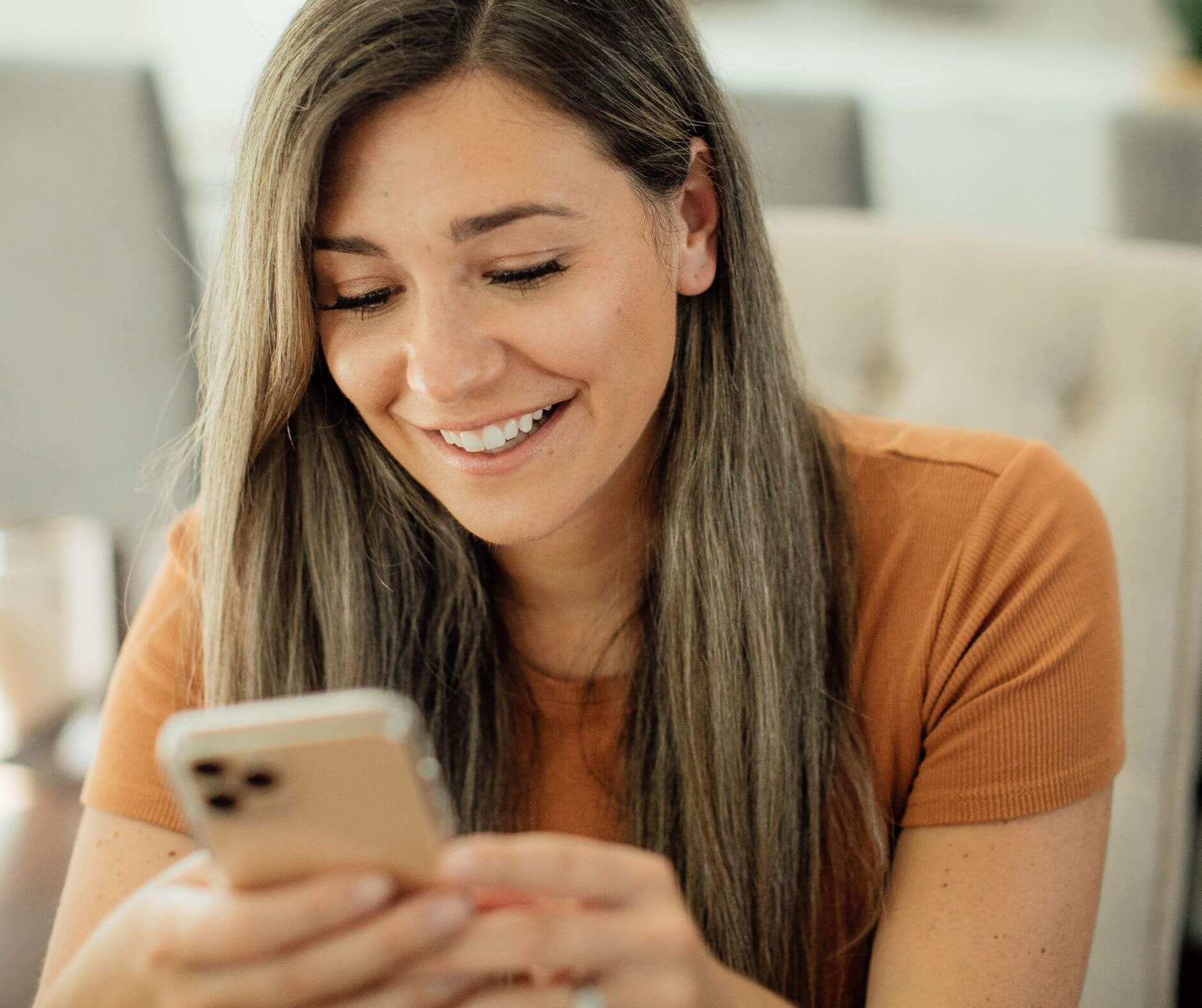 Woman laughing on mobile as she reads web design strategy tips
