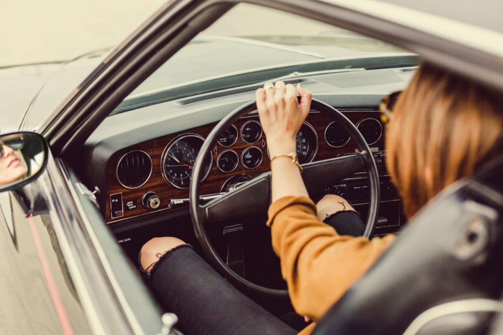 Woman driving a classic car with hands on the steering wheel in portland, oregon.