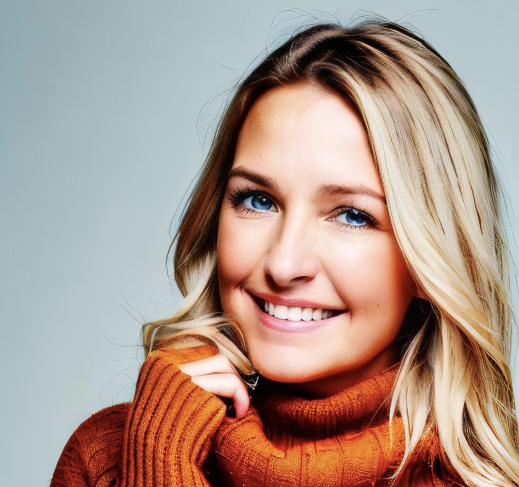 A smiling woman in an orange sweater.